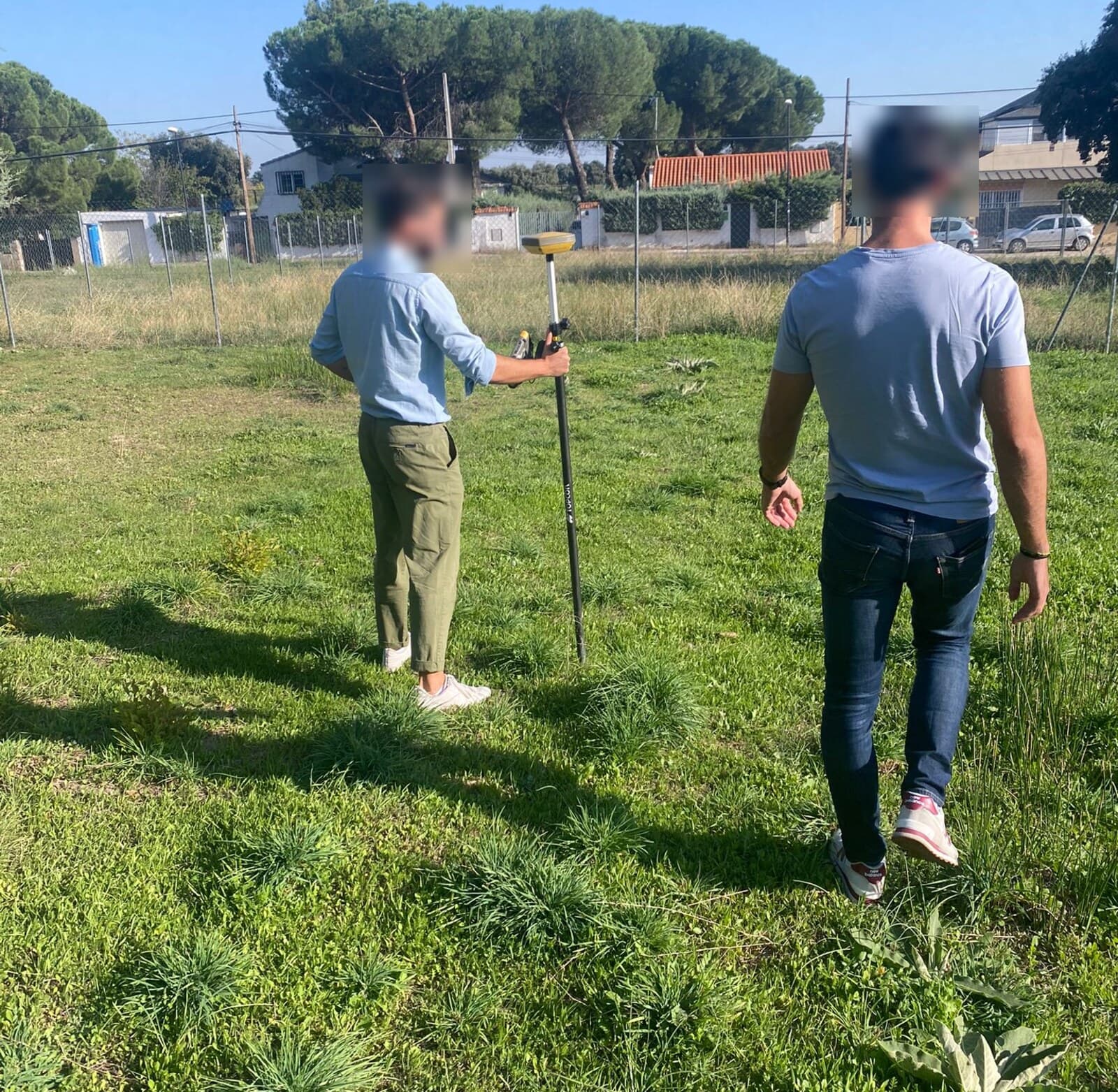 Toma de datos con receptor GNSS sobre jalón en una finca de hierba en Galapagar